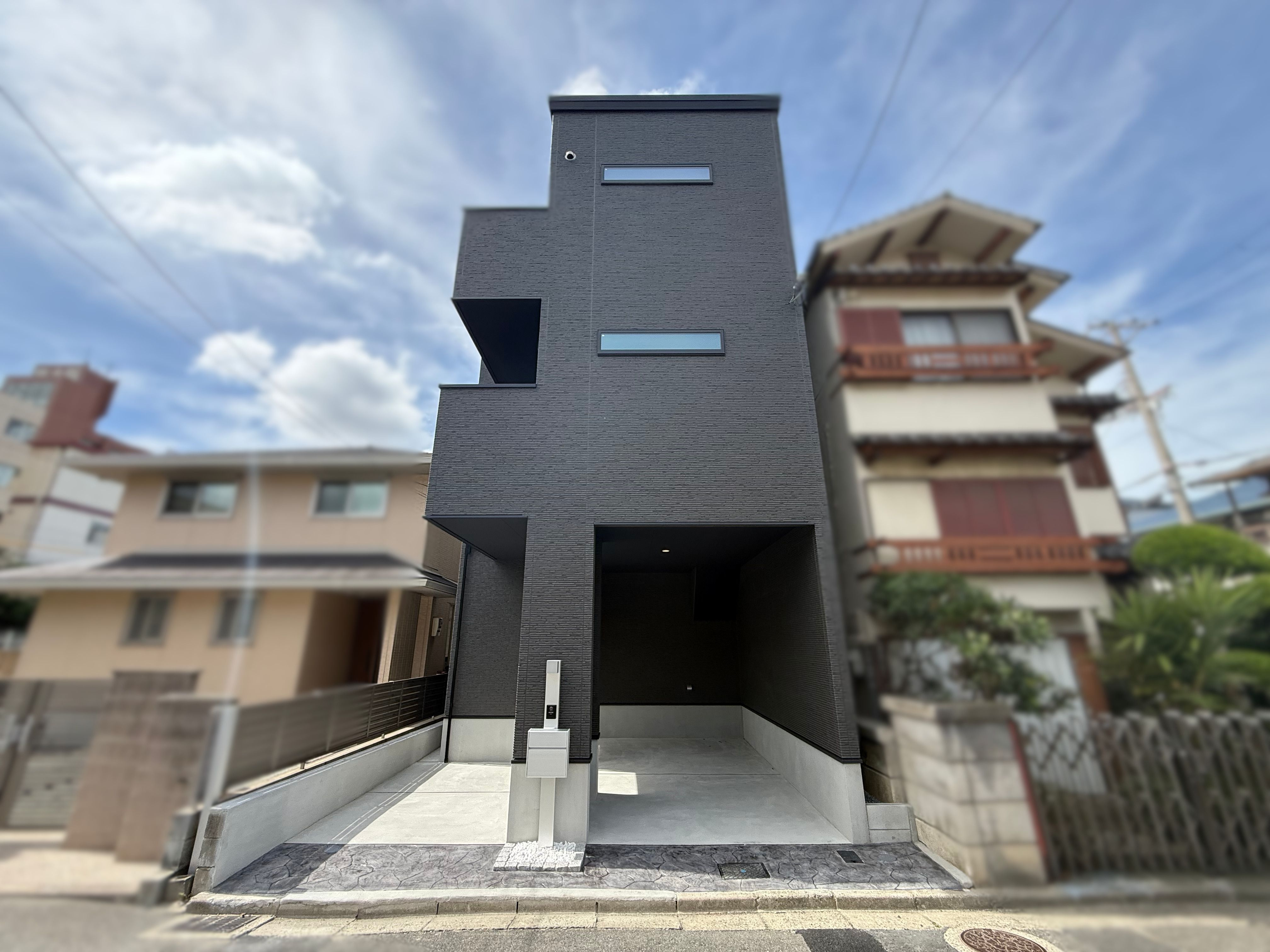 #93 都市の静寂を纏う、黒のソリッドフォルム。木目が息づく伸びやかな住空間。の画像