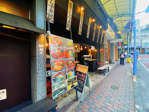 商店街の途中で立ち止まる浦上の写真