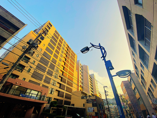 商店街の通りを前に歩く浦上の写真