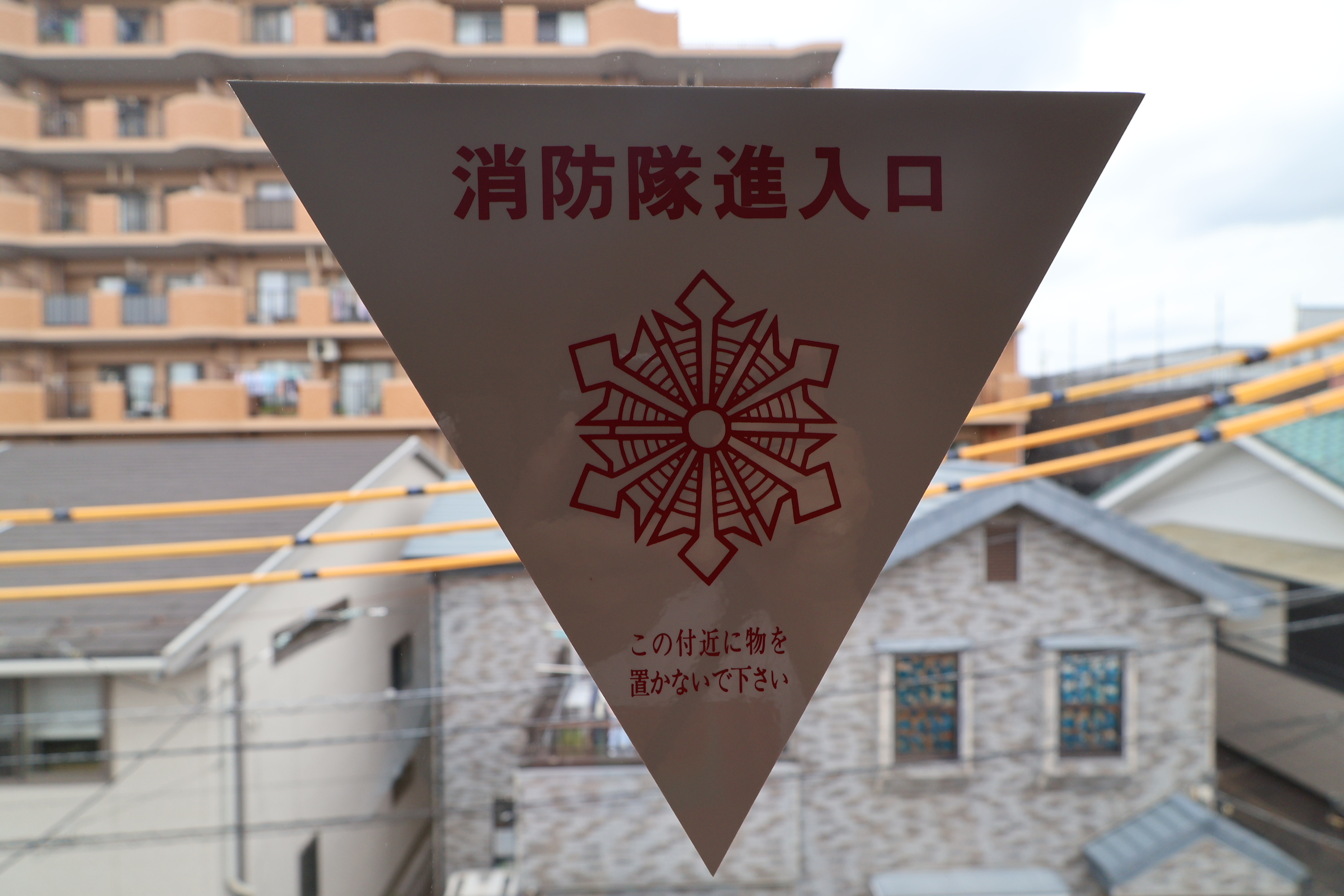 窓に貼ってある三角のシール▼(消防隊進入口)に防犯フィルムを貼ってもOK?の画像