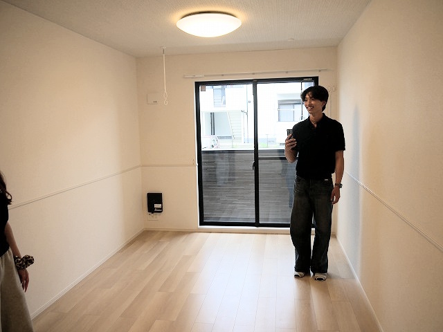 新築物件ならではの木目調の建具や腰壁調のおしゃれなデザインを真剣にチェックする天理大生