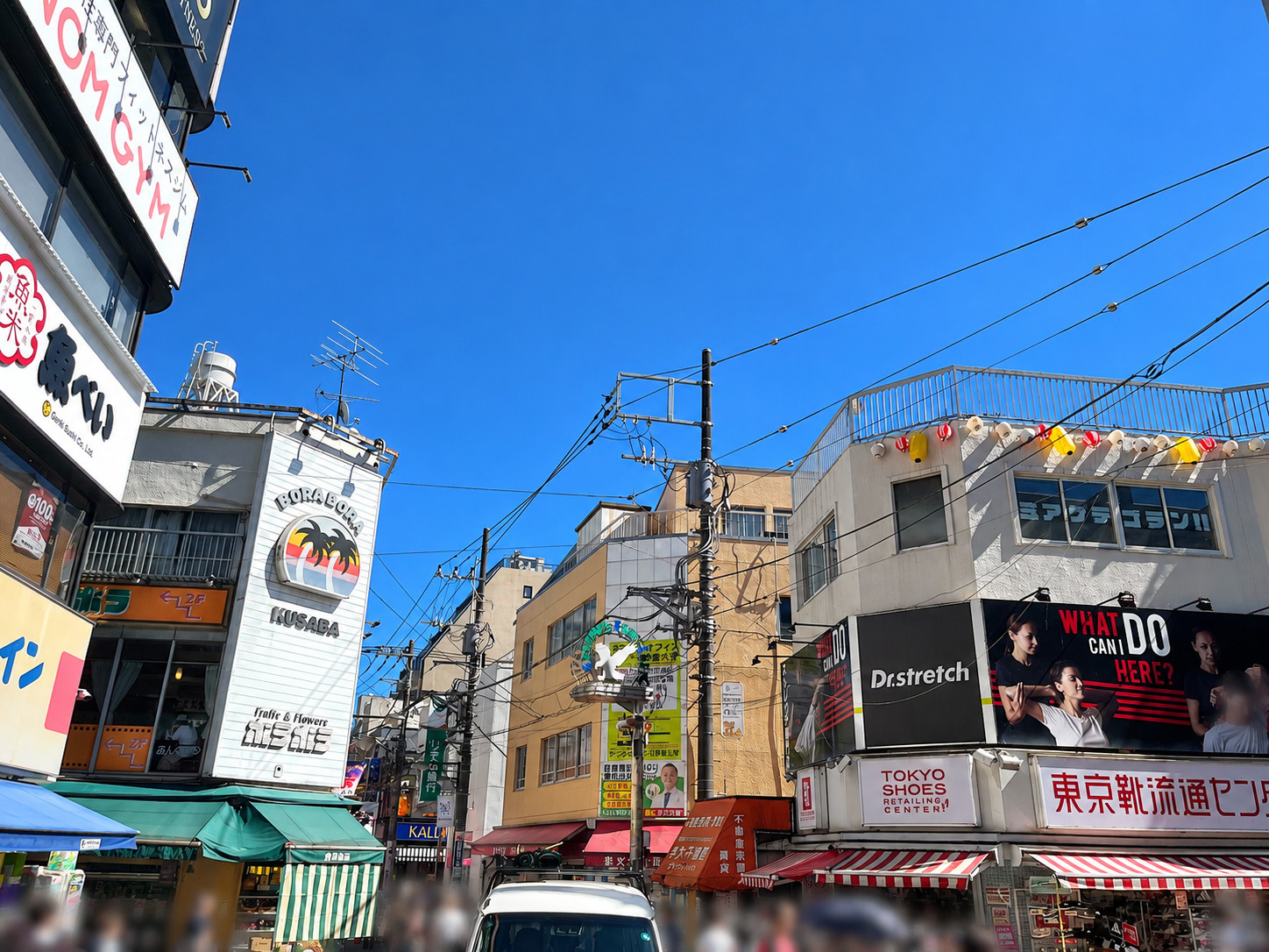 学芸大学駅を出た商店街。細い道路と昔からの建物が残る駅前の街並み
