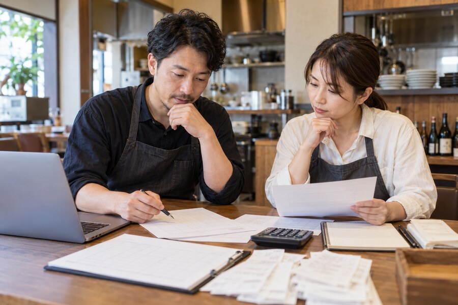 店舗経営者が勤務体制や人件費を確認しているイメージ